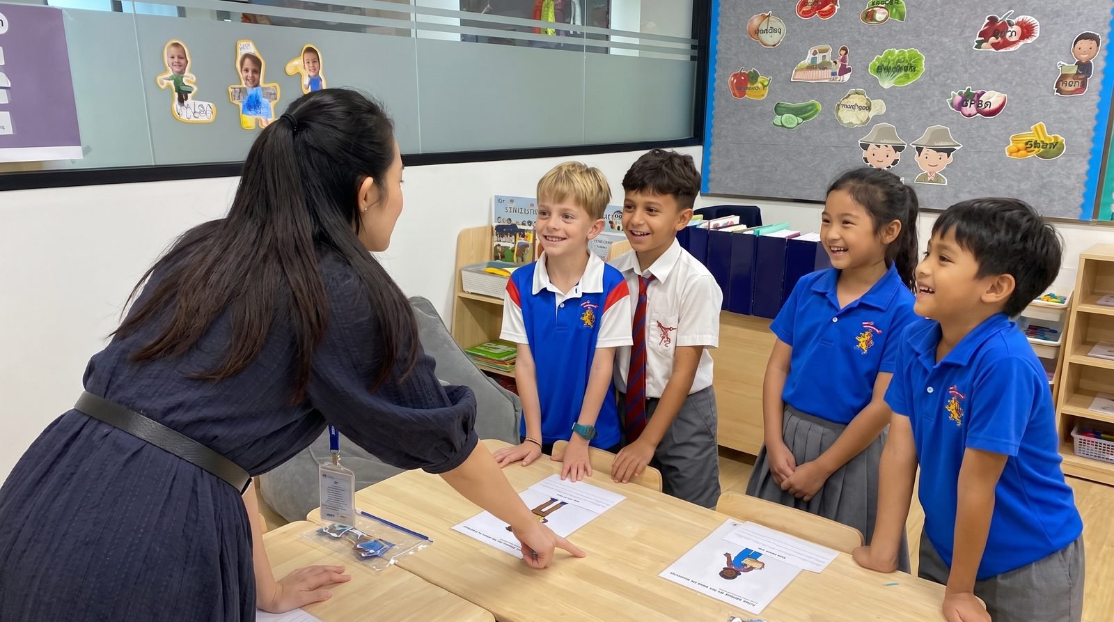 Kru Ice teaching a small group of smiling students in a classroom